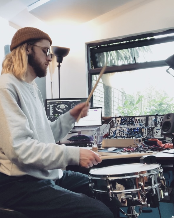 Gregory White playing a snare drum with Sensory Percussion and modular synthesisers.